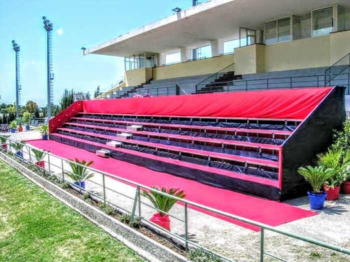 Tribuna a gradoni con copertura rossa e tappeto