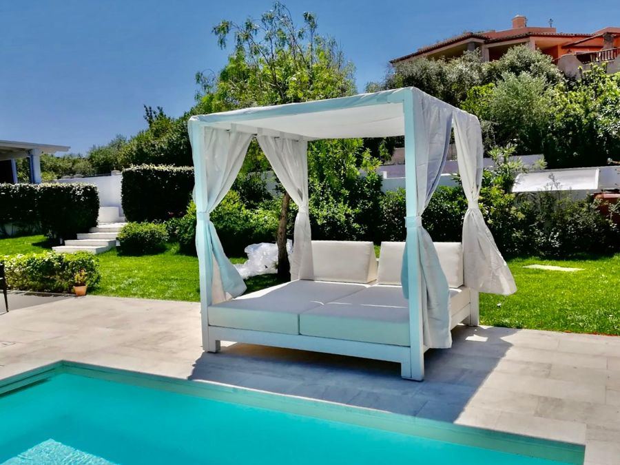 Letto a baldacchino bianco a bordo piscina