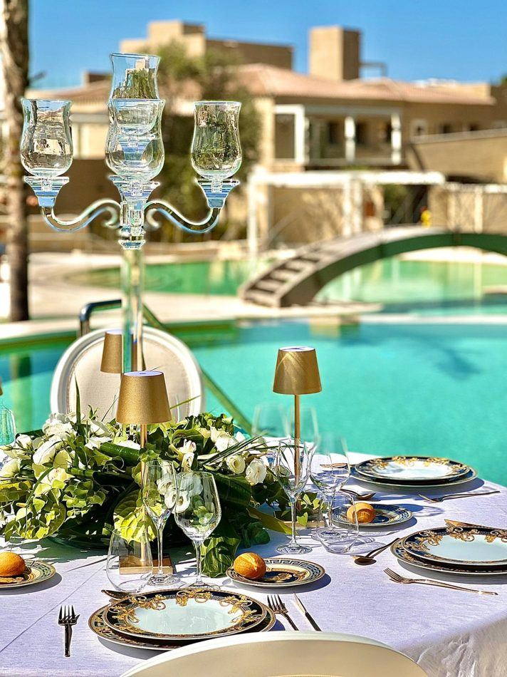 Tavola con candelabro in cristallo e piatti Versace a bordo piscina