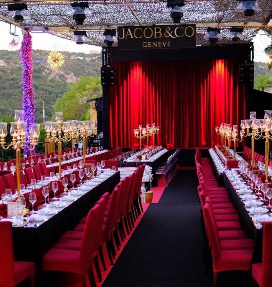 Cena di gala Jacob & Co con sedie rosse e candelabri dorati