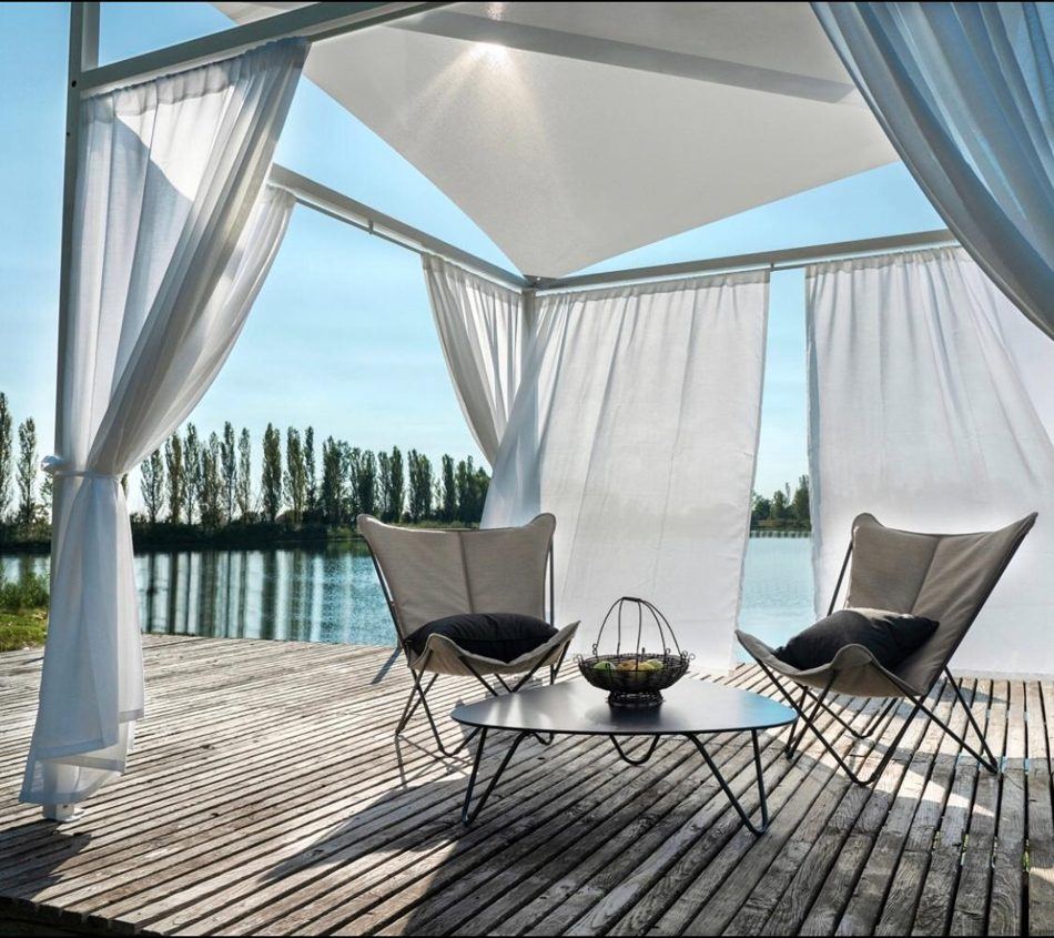 Gazebo bianco con tende su pontile in riva al lago
