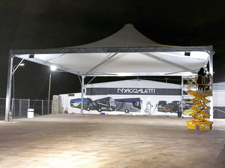 Gazebo a pagoda montato di notte davanti a un deposito autobus