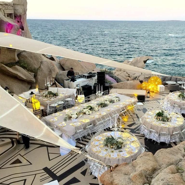 Cena su pedana tra le rocce di granito in riva al mare