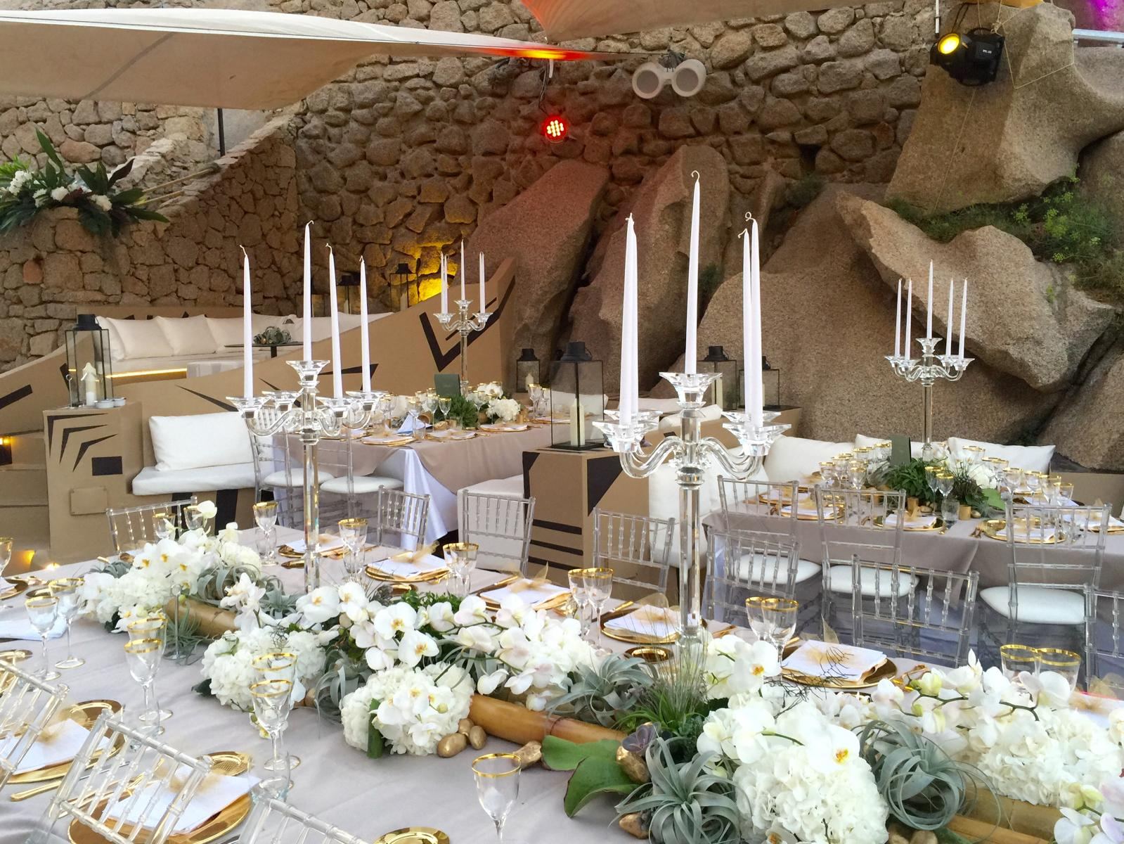 Tavolata con candelabri in cristallo e orchidee tra le rocce